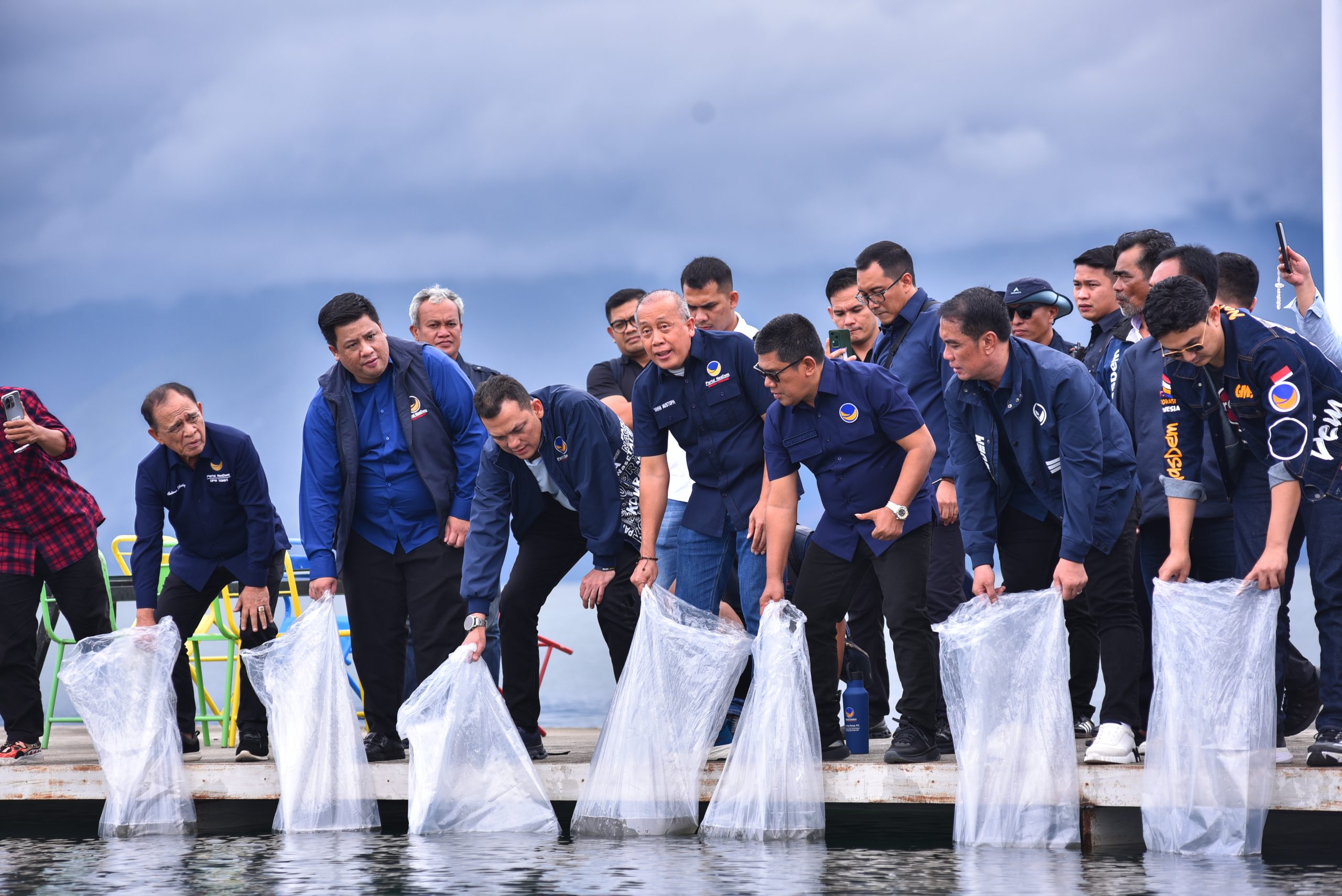 Wakil Ketua DPR RI, Saan Mustopa, saat menebar ribuan benih ikan ke Danau Toba dalam kunjungannya ke Sumatera Utara, Sabtu (11/1/2025). Foto: Eno/vel.